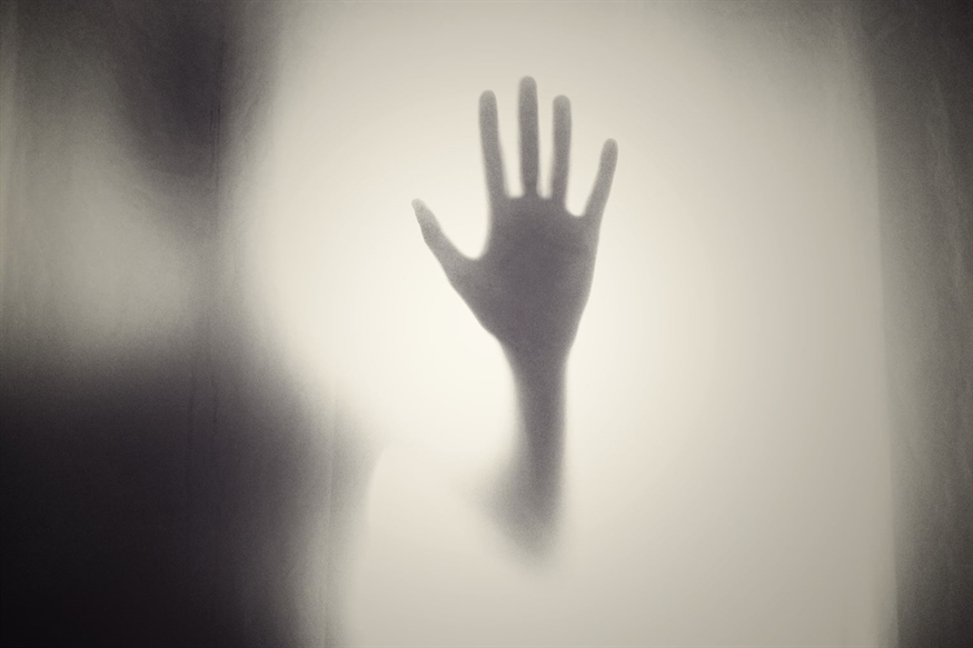 [ai] A shadow of a hand reaching out against a softly illuminated background, creating a sense of separation and distance.